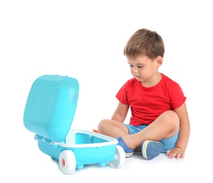 Photo of Cute little boy sitting with blue suitcase on white background