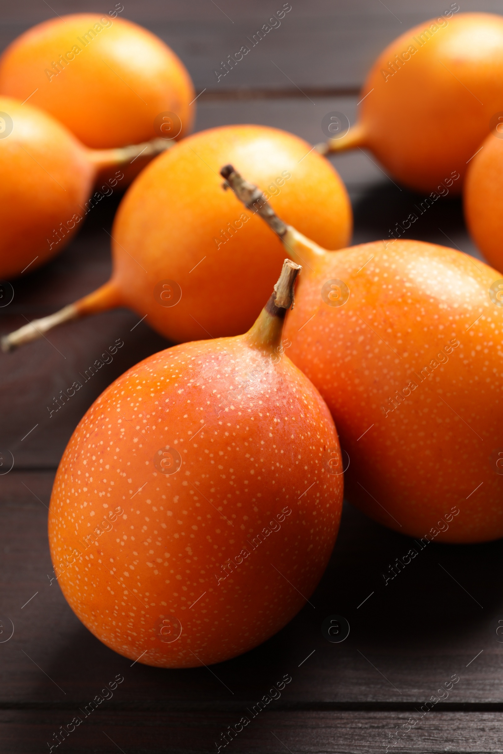 Photo of Delicious ripe granadillas on wooden table, closeup