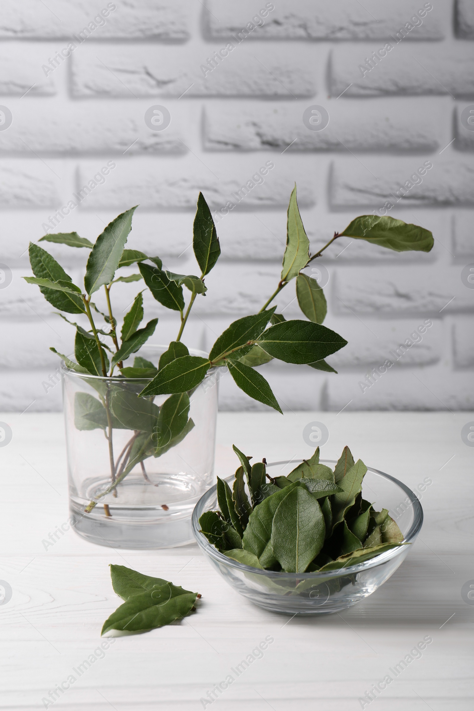 Photo of Fresh green bay leaves on white wooden table