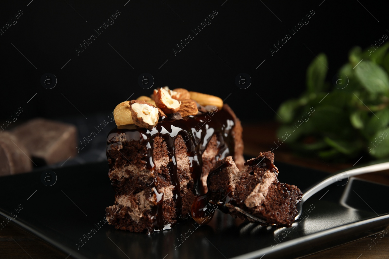 Photo of Piece of tasty homemade chocolate cake with nuts on plate, closeup