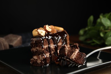 Photo of Piece of tasty homemade chocolate cake with nuts on plate, closeup