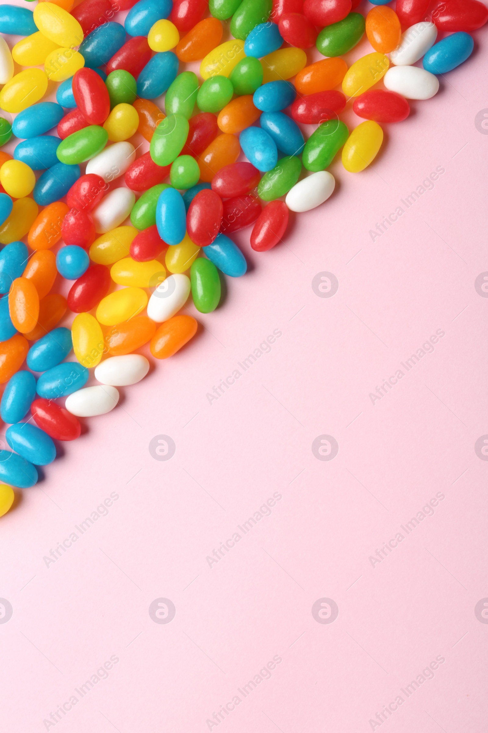 Photo of Flat lay composition with delicious jelly beans on light background. Space for text