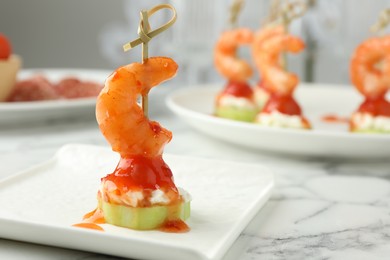 Photo of Tasty canape with shrimp, vegetables and cream cheese on white marble table, closeup. Space for text