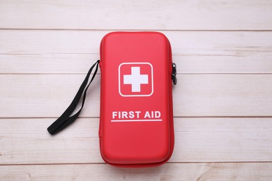 Photo of Medicine bag on wooden table, top view. First aid kit