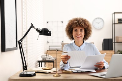 Photo of Happy notary working with documents at workplace in office
