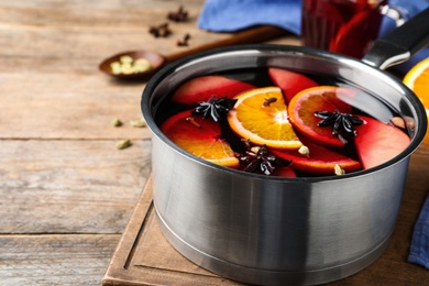Delicious mulled wine on wooden table, closeup