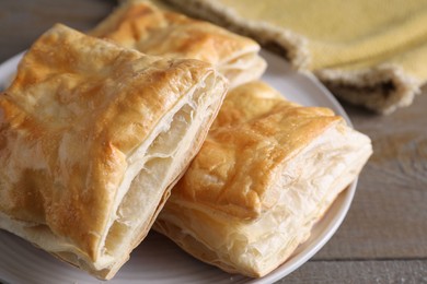 Delicious fresh puff pastries on wooden table, closeup