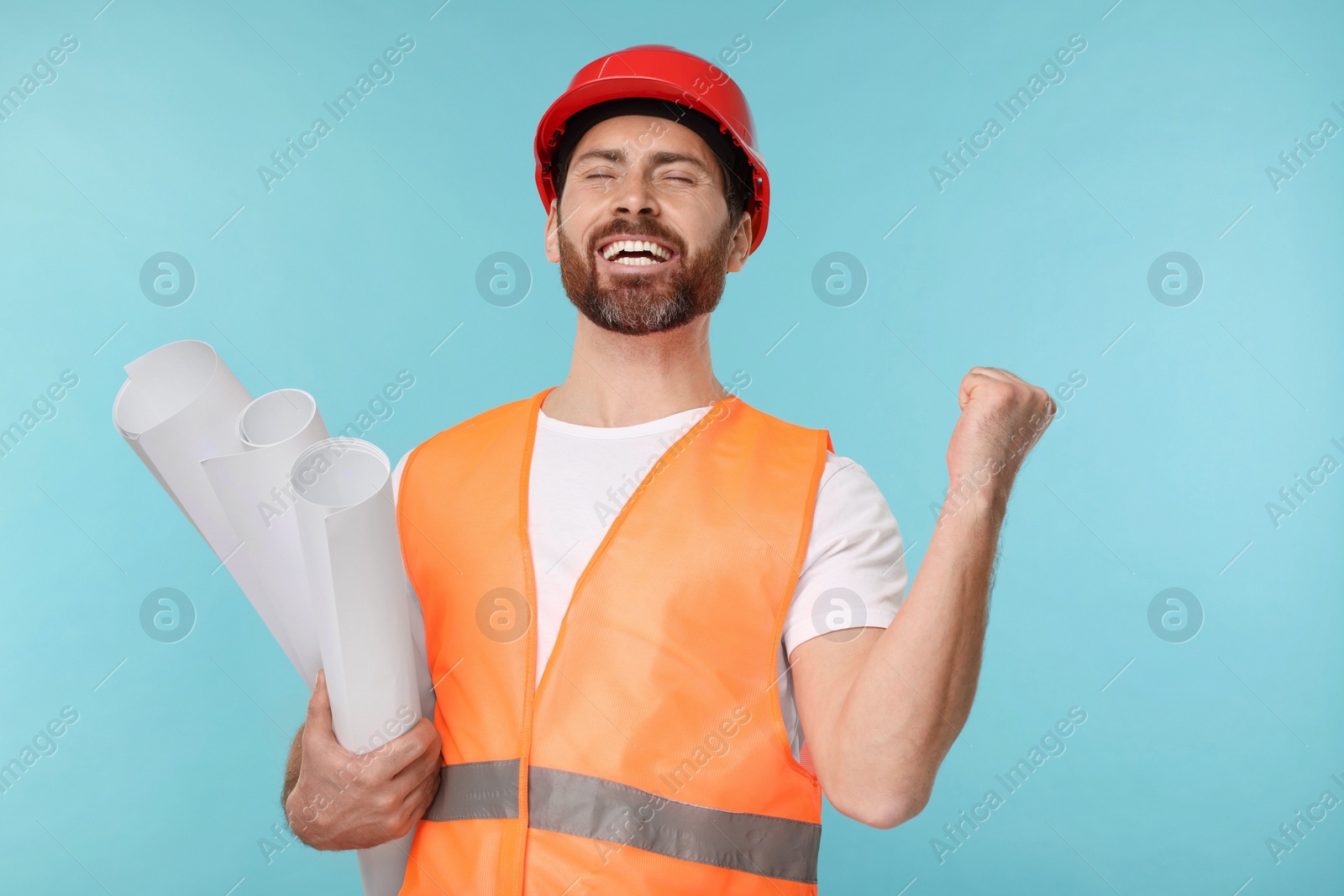 Photo of Architect in hard hat with drafts on light blue background