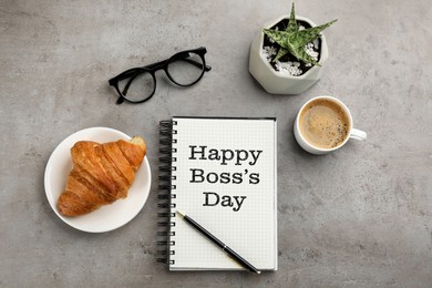 Image of Happy Boss`s Day greeting card. Notebook with phrase, pen, coffee, croissant, glasses and plant on grey table, flat lay