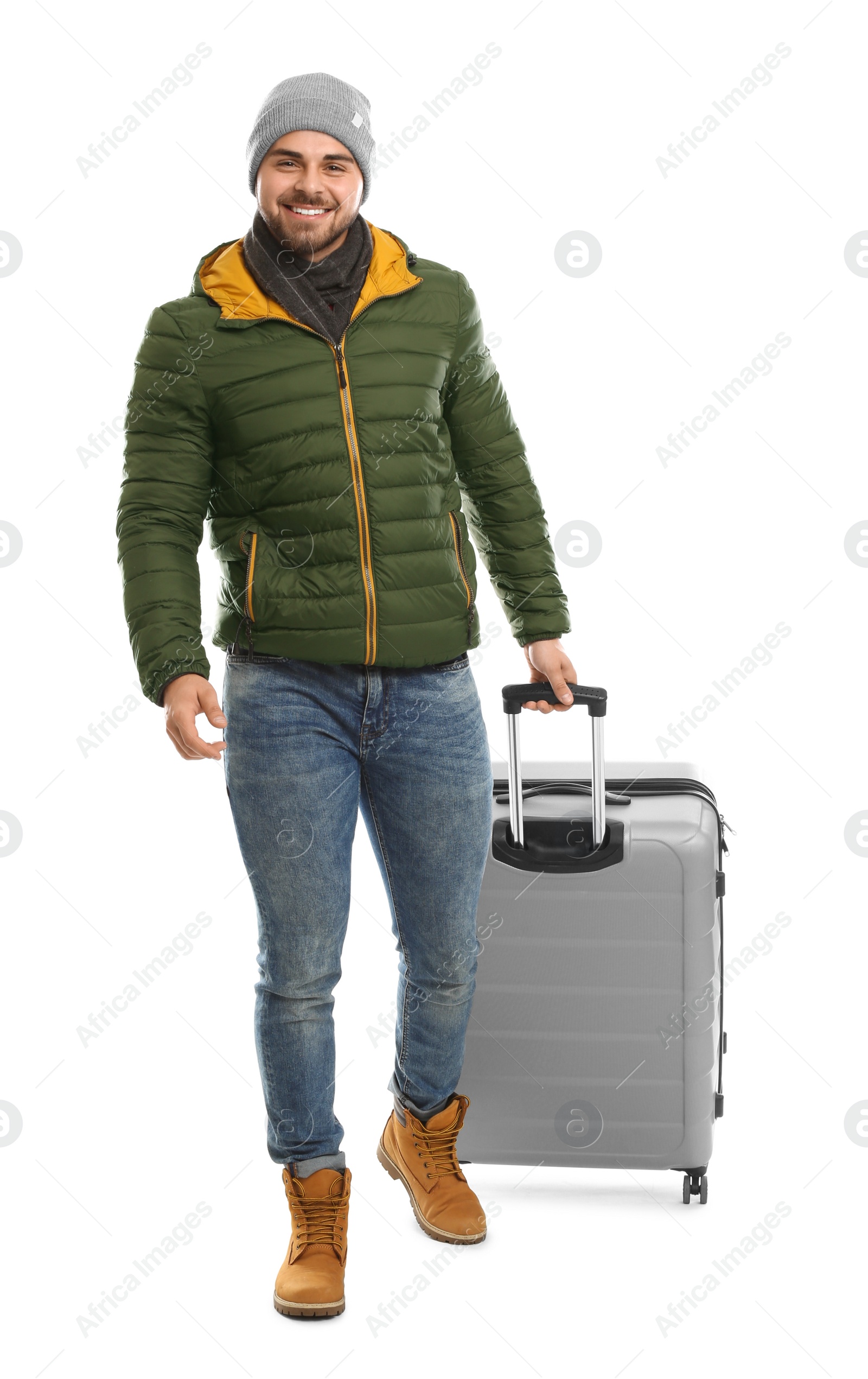 Photo of Young man in warm clothes with suitcase on white background. Winter vacation