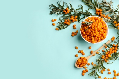 Photo of Fresh ripe sea buckthorn on light blue background, flat lay. Space for text