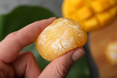 Photo of Woman holding delicious mango mochi, closeup. Japanese cuisine
