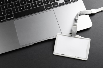 Photo of Blank badge and laptop on grey background, top view