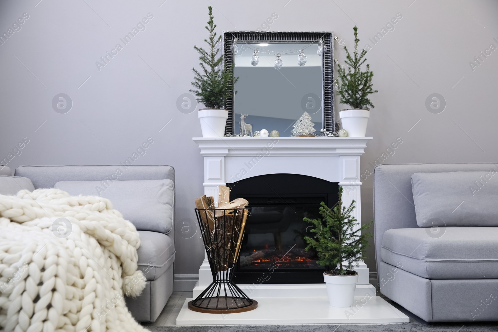 Photo of Stylish living room interior with little fir trees and Christmas decorations