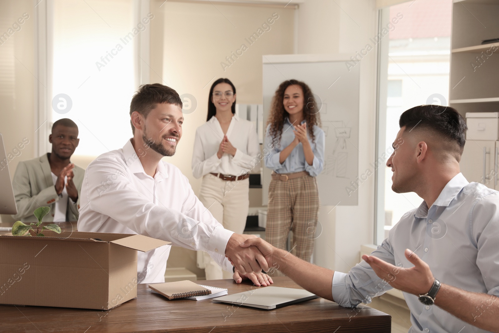 Photo of Employee shaking hand with new coworker in office