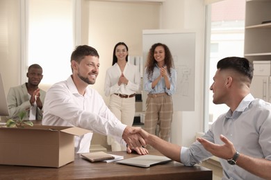 Photo of Employee shaking hand with new coworker in office