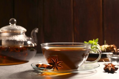 Aromatic tea with anise stars on light grey table