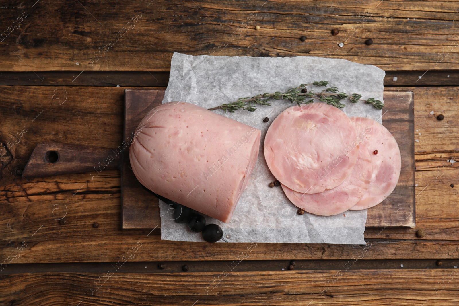 Photo of Tasty ham with thyme and pepper on wooden table, flat lay