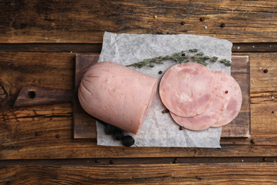 Tasty ham with thyme and pepper on wooden table, flat lay