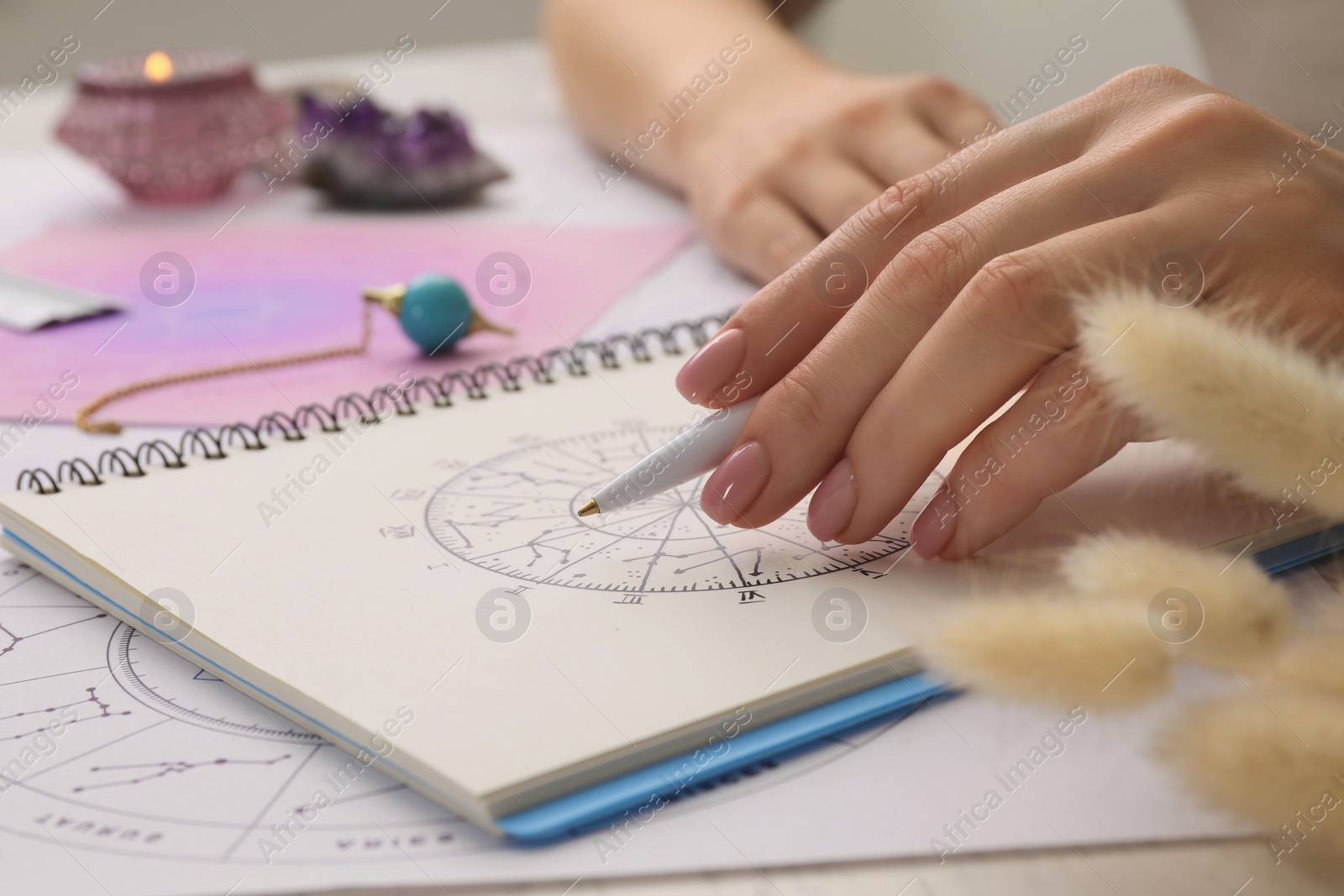 Photo of Astrologer using zodiac wheel for fate forecast at table, closeup. Fortune telling