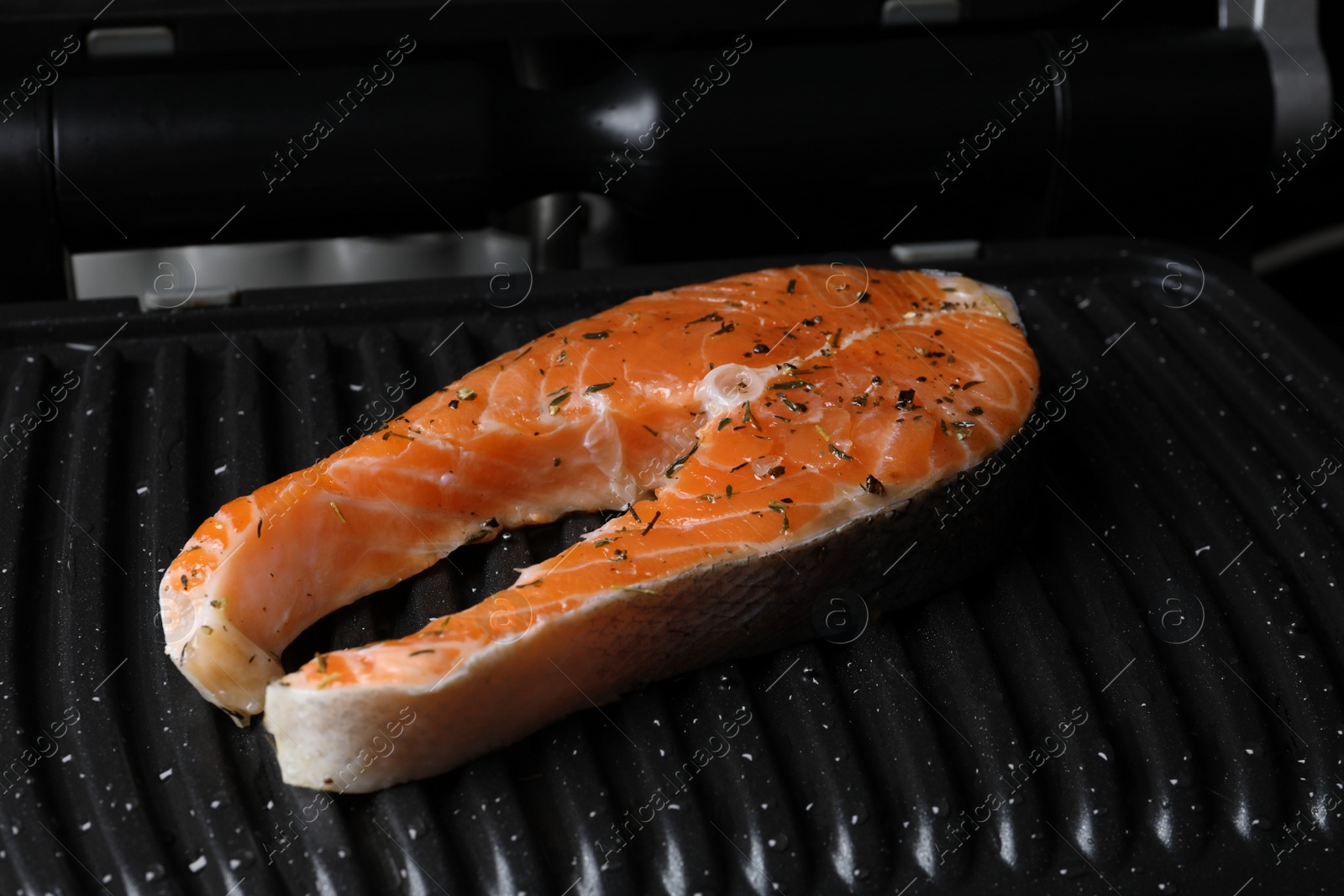 Photo of Cooking salmon. Grill with fresh fish steak and spices