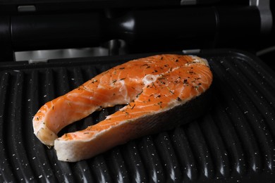 Photo of Cooking salmon. Grill with fresh fish steak and spices