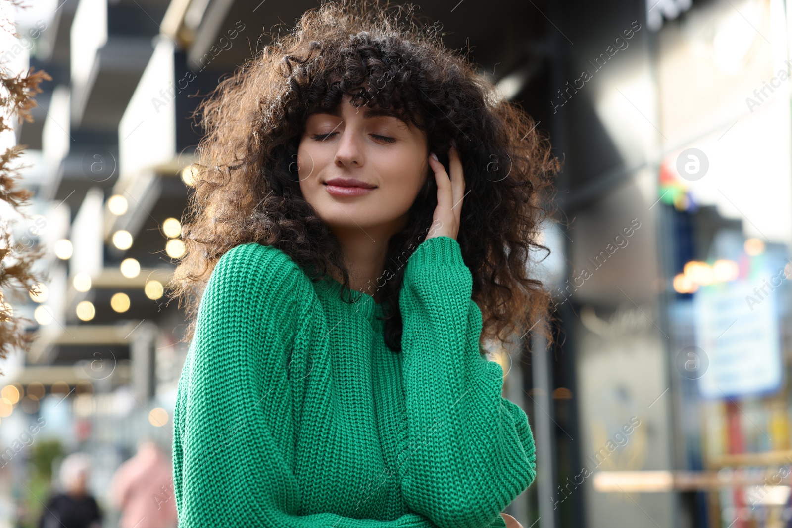 Photo of Young woman in stylish green sweater outdoors