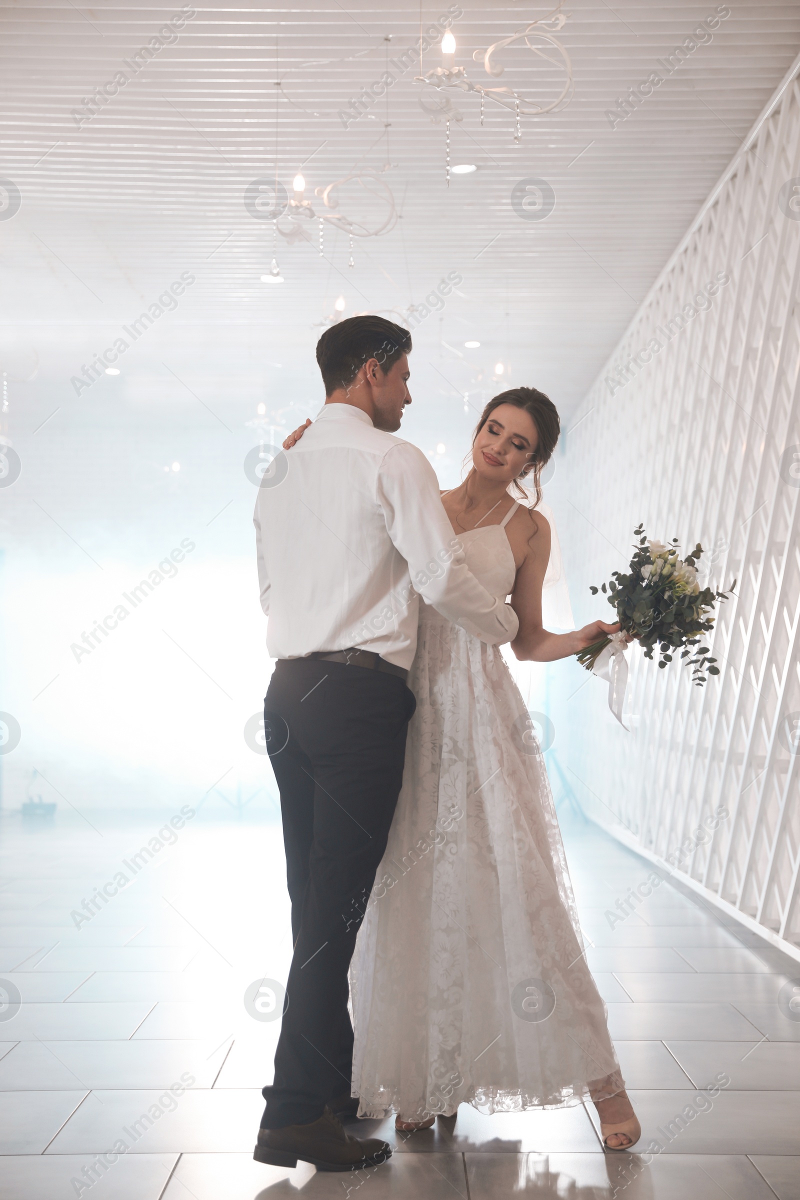 Photo of Happy newlywed couple dancing together in festive hall