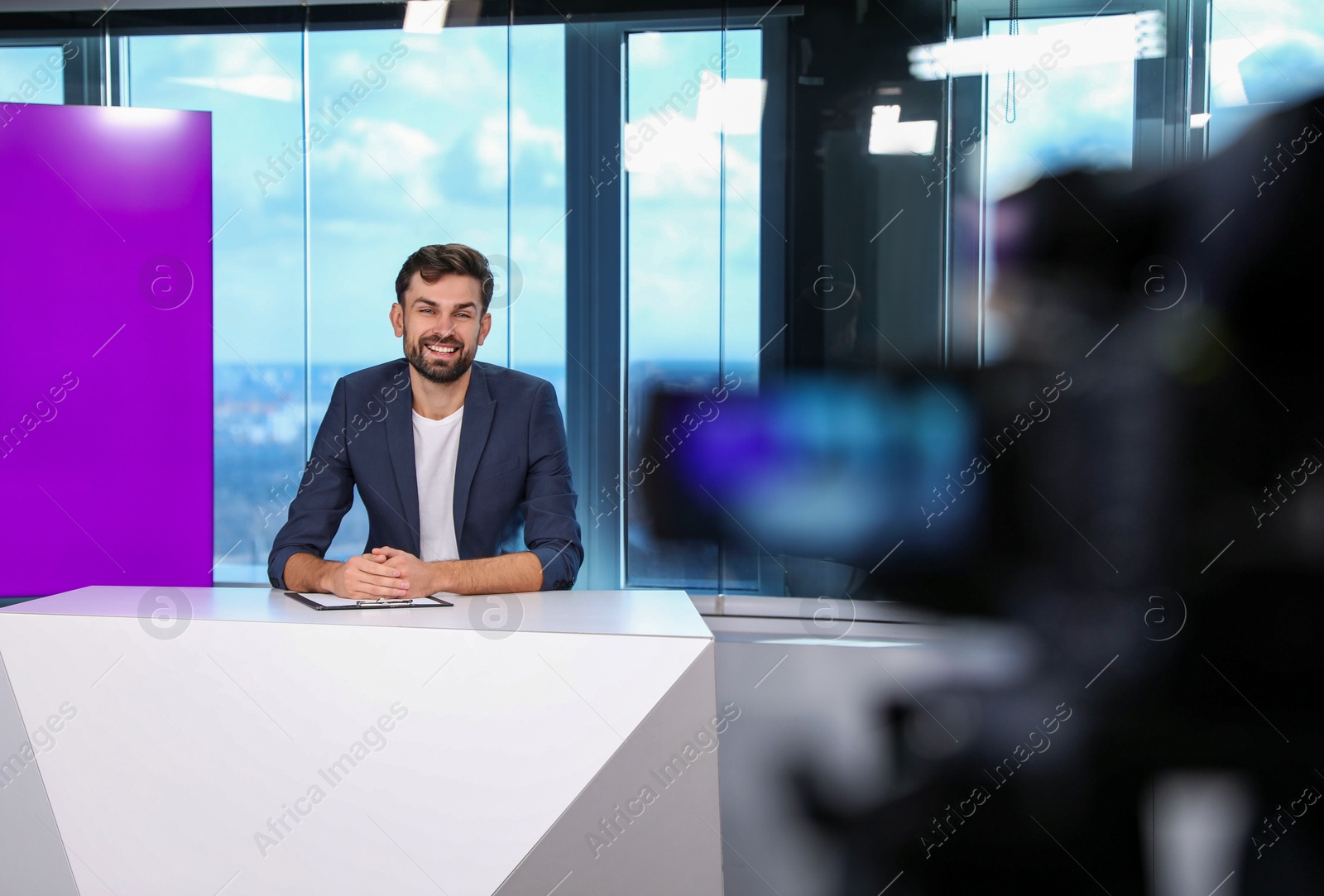 Photo of Presenter and video camera operator working in studio. News broadcasting