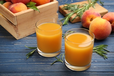 Photo of Natural peach juice and fresh fruits on blue wooden table