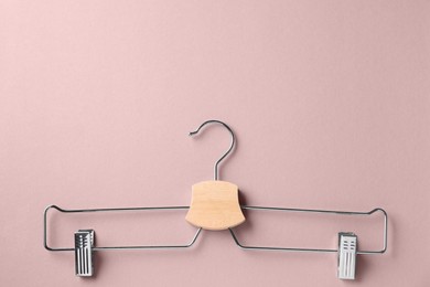 Photo of Hanger with clips on beige background, top view. Space for text