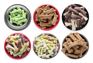 Image of Set with different bone shaped dog cookies in feeding bowls on white background, top view