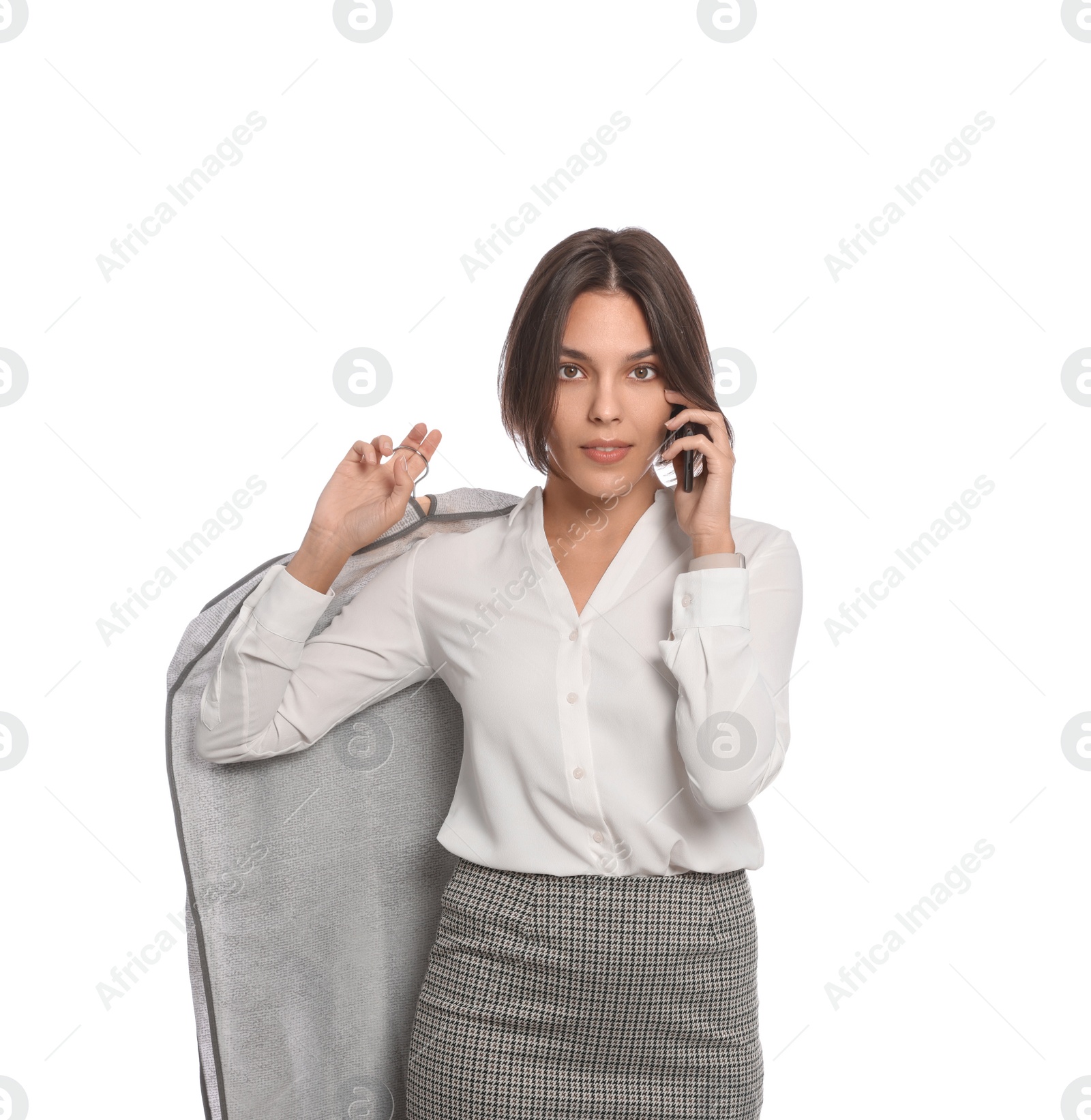 Photo of Woman holding garment cover with clothes while talking on phone, isolated on white. Dry-cleaning service