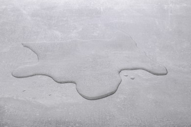 Photo of Puddle of water on light grey surface