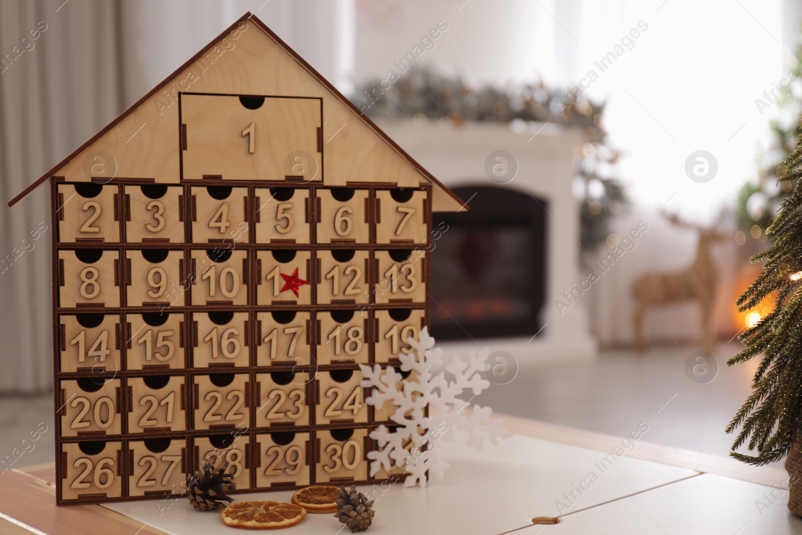 Photo of Wooden house shaped Advent calendar in room decorated for New Year