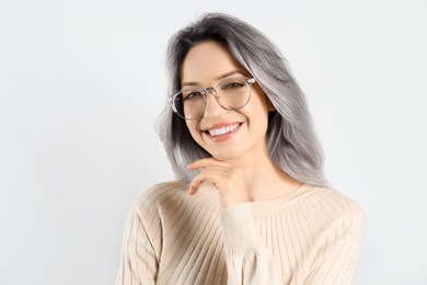 Image of Portrait of smiling woman with ash hair color on light background