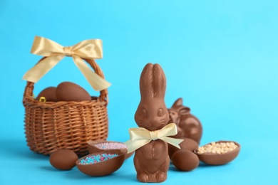 Photo of Chocolate Easter bunnies and eggs on light blue background