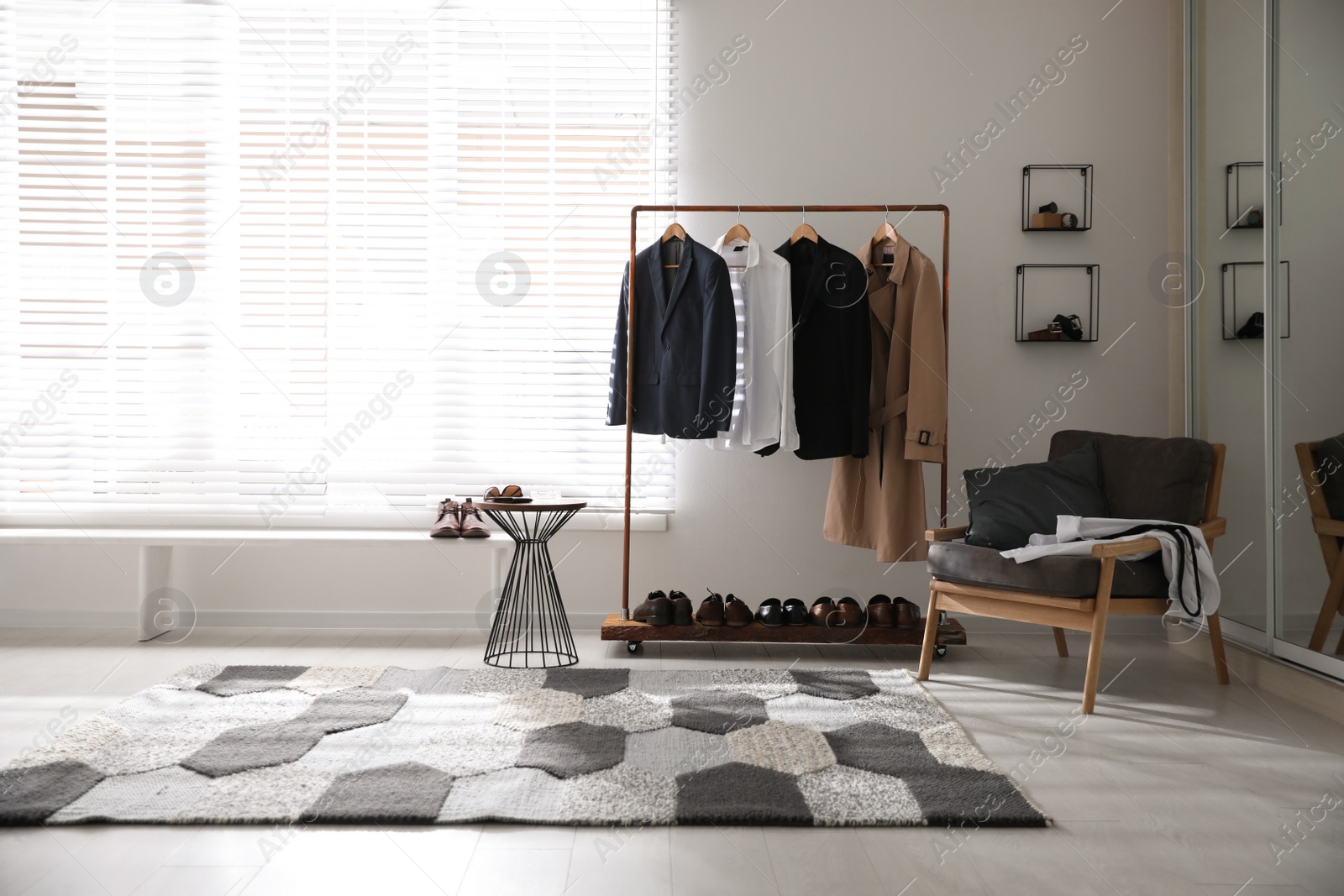 Photo of Dressing room interior with clothing rack and armchair