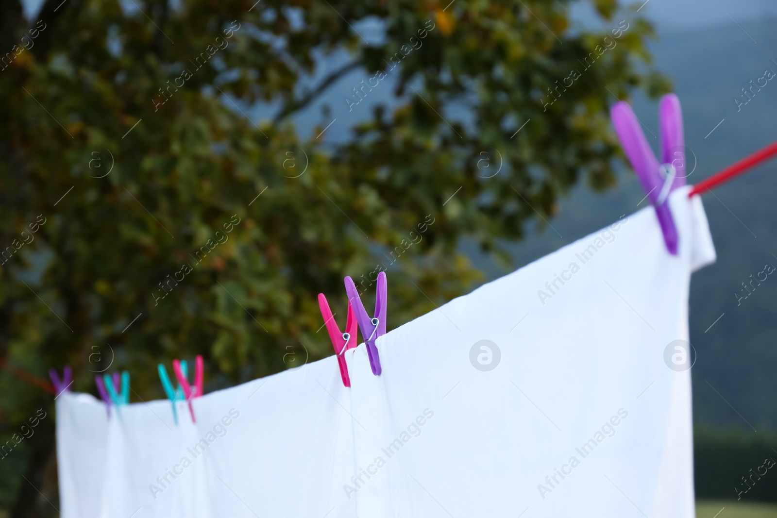 Photo of Bedclothes hanging on washing line outdoors, closeup