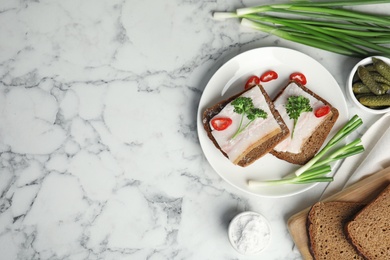 Plate with pork fatback sandwiches served on marble background, flat lay. Space for text