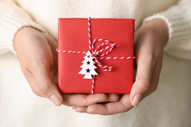 Woman holding beautifully wrapped Christmas gift box, closeup