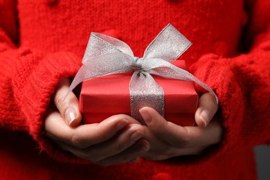 Woman holding gift box with bow as background, closeup