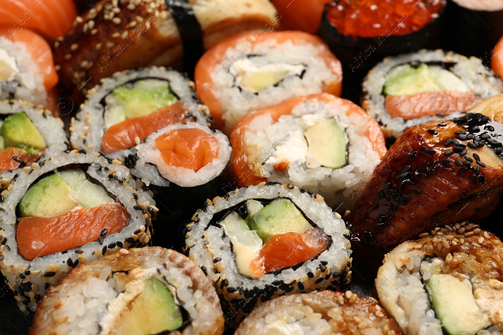 Photo of Different tasty sushi rolls as background, closeup