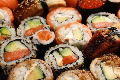 Photo of Different tasty sushi rolls as background, closeup