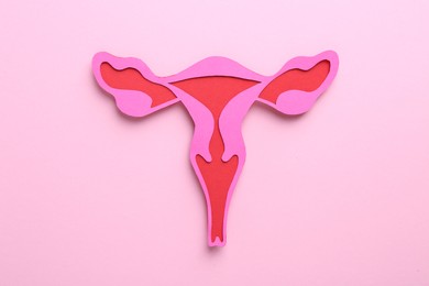Reproductive medicine. Paper uterus on pink background, top view