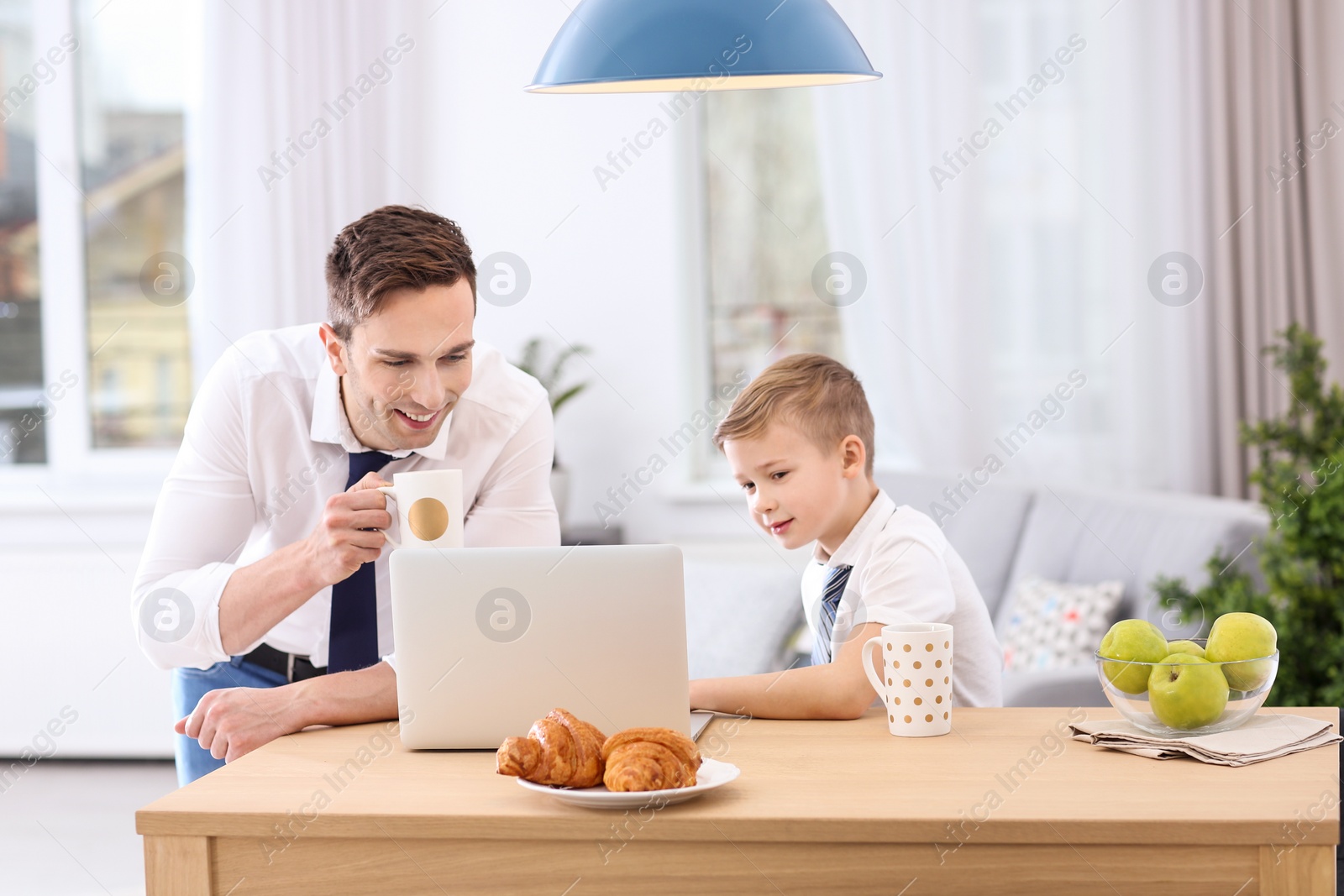 Photo of Dad and his son with laptop at home