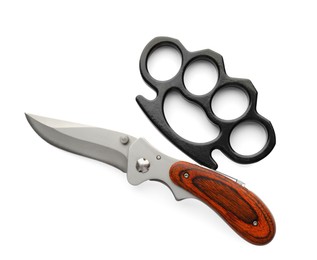 Photo of Black brass knuckles and knife on white background, top view