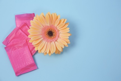 Photo of Flat lay composition with flower and menstrual pads on color background. Gynecological checkup