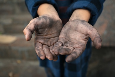 Poor homeless child begging for help outdoors, closeup