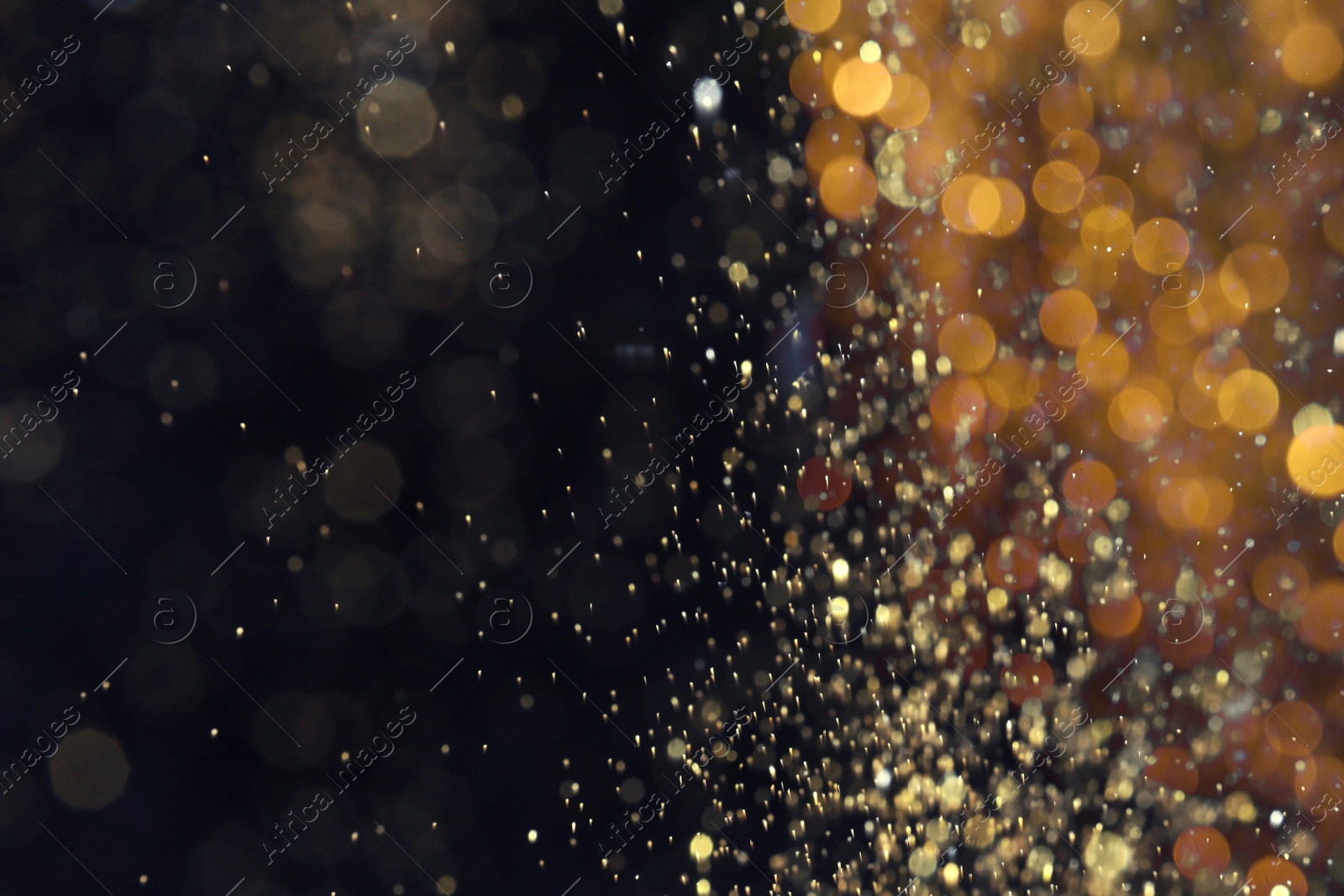 Photo of Blurred view of golden lights on black background, space for text. Bokeh effect